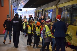 3 dzieci w towarzystwie policjantów i pracowników Polregio wsiadają do pociągu