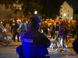 policjant stojący tyłem podczas zabezpieczenia protestu