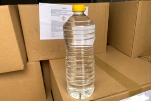 plastikowa butelka z przezroczystym płynem stojąca na kartonie