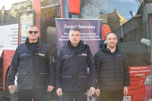 Komendant krakowskiej policji w towarzystwie policjantów zaangażowanych w zbiórkę krwi stojący przed autobusem