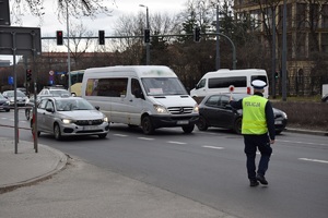 policjant ruchu drogowego zatrzymuje do kontroli drogowej kierowcę taksówki na jednej z dróg Krakowa