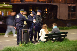 policjanci i strażnicy miejscy podczas legitymowania dwójki osób spożywających alkohol na bulwarach