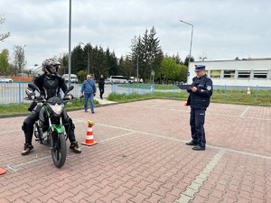 policjant nadzoruję jazdę motocyklem jednego z uczestników turnieju