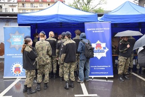 na dziedzińcu komendy odwiedzający stoją przy stoisku profilaktycznym