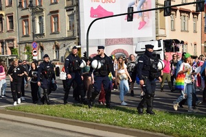 umundurowani policjanci idący obok uczestników marszu przez jedną z krakowskich ulic