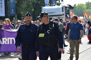 Zastępca Komendanta Miejskiego Policji w Krakowie w towarzystwie funkcjonariusza straży miejskiej idący przed osobami biorącymi udział w marszu