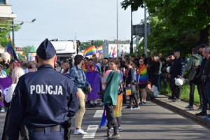 Zastępca Komendanta Miejskiego Policji w Krakowie ustawiony tyłem do zdjęcia obserwuje uczestników marszu