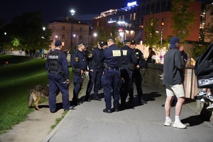 policjanci i strażnicy miejscy stojący na Bulwarze Czerwieńskiego. Obok oraz w tle widać przechodniów