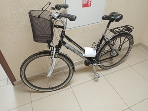 jeden z zabezpieczonych rowerów w kolorze czarnym oraz koszykiem zamocowanym przy kierownicy oparty o ścianę na korytarzu w komisariacie policji