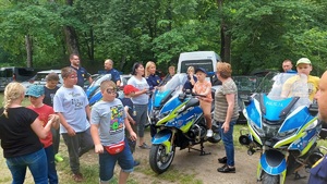 Policjanci i uczestnicy wydarzenia oglądający policyjne motocykle.