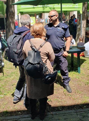 Policjant rozmawia z seniorami o zasadach bezpieczeństwa.