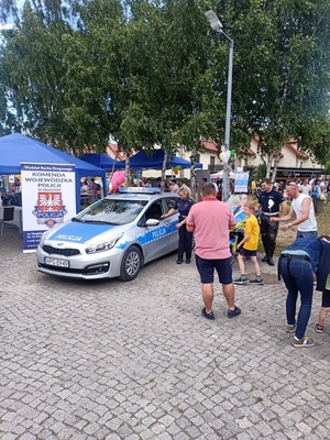 Policjanci prezentują uczestnikom imprezy radiowóz i motocykl