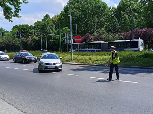 Policjant na drodze zatrzymuje do kontroli taksówkę wskazując jednocześnie miejsce w którym ma się zatrzymać