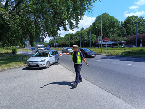 Policjant wskazuje kierowcy taksówki miejsce w którym ma się zatrzymać celem kontroli