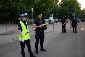 Kilku policjantów przygotowujących się do zabezpieczenia pochodu zawodników na ulicy Reymonta