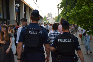 Patrol policji wśród tłumu przemieszczjącego się przed stadionem Wisły.