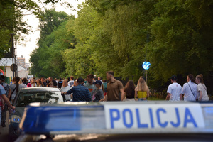 Policyjne sygnał z napisem policja. W tle widać tłum ludzi przed stadionem Wisły.