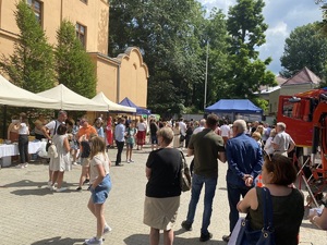 Uczestnicy wydarzenia stojący na placu przy stoiskach profilaktycznych.