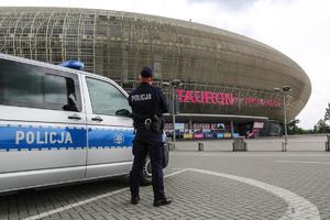 umundurowany policjant stojący przy radiowozie przed Tauron Areną