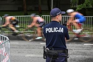 Umundurowany policjant zabezpieczający przejazd kolarzy.