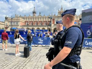 dwóch umundurowanych policjantów w trakcie patrolu na krakowskim Rynku Głównym