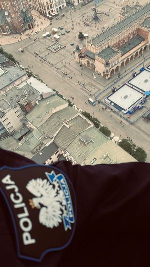 widok na krakowski Rynek Główny z policyjnego śmigłowca. Na dole zdjęcia widać naszywkę na rękawie z napisem policja