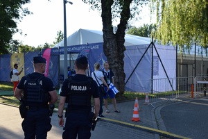 dwóch umundurowanych policjantów stojących tyłem do zdjęcia w rejonie Wioski Zawodniczej