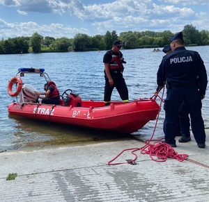 policjanci i strażacy wodują ponton na zalewie Bagry