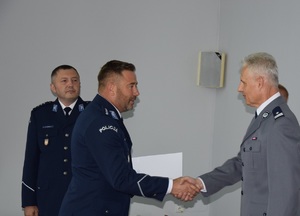 Zastępca komendanta krakowskiej komendy miejskiej gratuluje nowo powołanemu funkcjonariuszowi na stanowisko zastępcy komendanta komisariatu