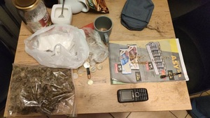 zabezpieczone narkotyki, monety, gazeta, torebka oraz inne rzeczy znajdujące się na stole
