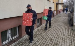 Policjanci niosą paczki do klatki bloku