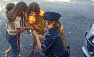 dziewczynki w towarzystwie policjantki oglądają kajdanki