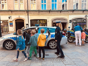dzieci oglądają policyjny radiowóz w towarzystwie policjantki