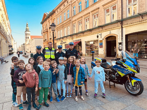 dzieci z policjantami pozują do zdjęcia na ulicy Grodzkiej w Krakowie