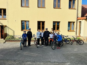 przed budynkiem wspólne zdjęcie policjantów z uczniami zdającymi na kartę rowerową