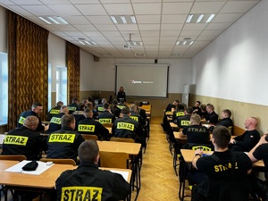 1 policjantka szkoli strażaków z zasad kierowania ruchem drogowym